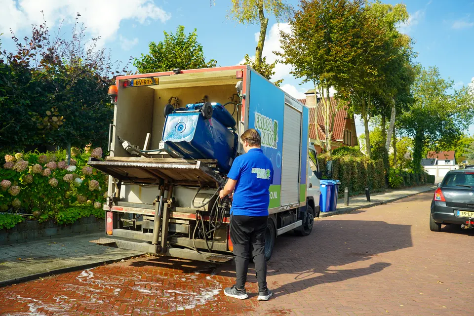 Een container wordt gekanteld in de wasinstallatie achter op de Frisse Kliko-wagen.